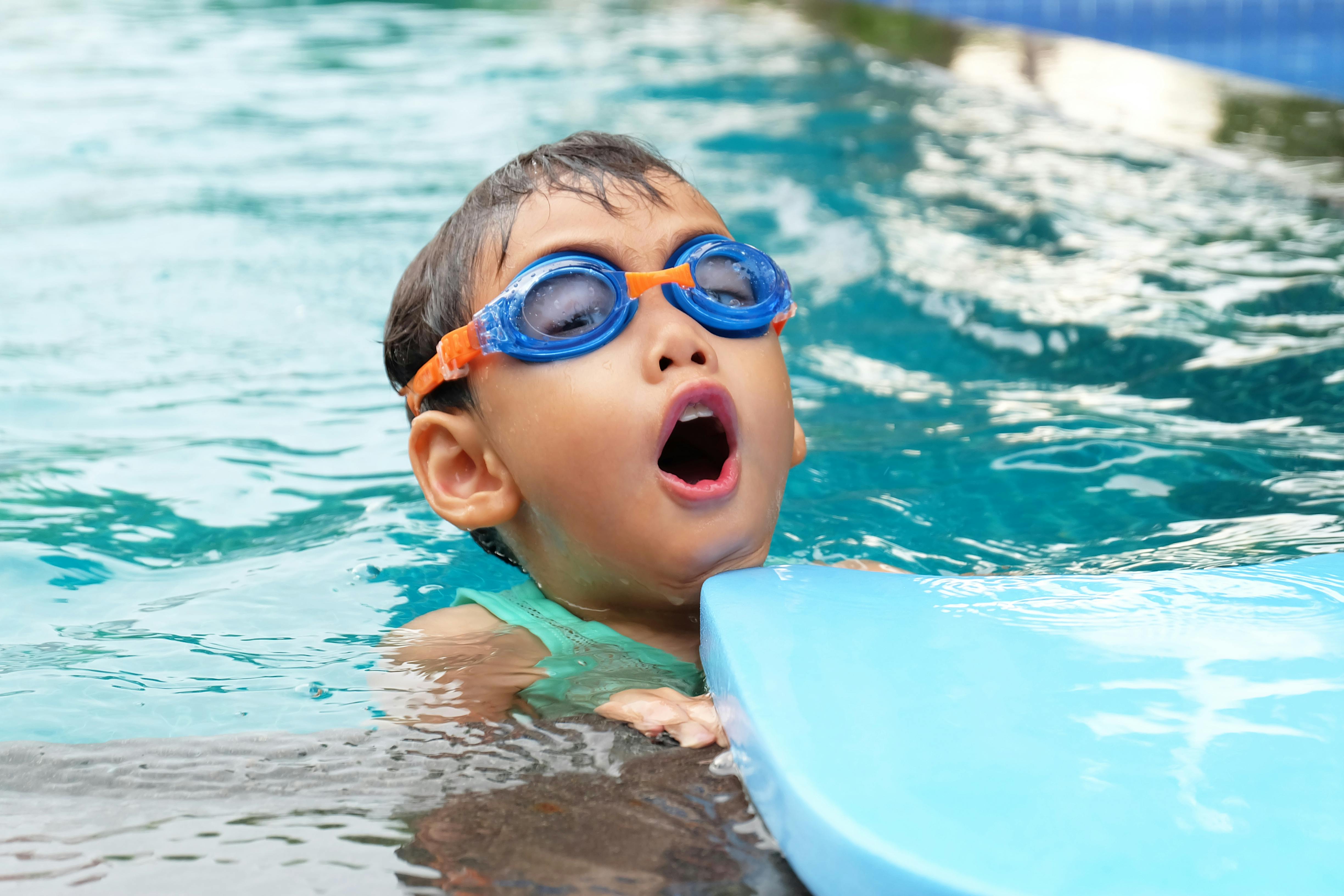 An image of a young child learning to swim in an indoor pool